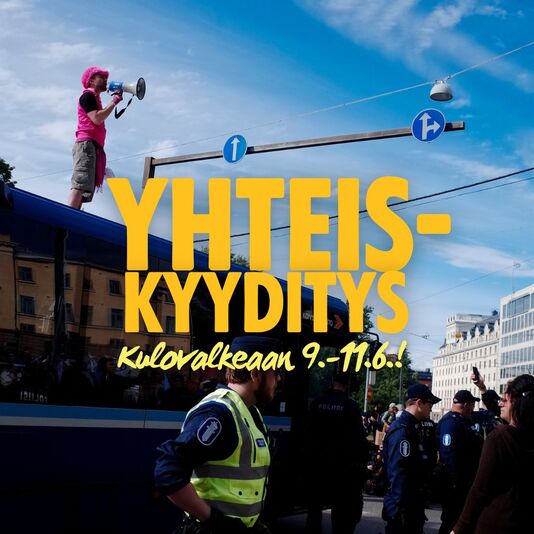 Kuva, jossa mielenosoittaja seisoo pysäkkikatoksen päällä pinkissä paidassa ja puhuu megafoniin. Alhaalla näkyy poliiseja. Kuvan päällä on teksti "YHTEISKYYDITYS Kulovalkean 9.-11.6.!"